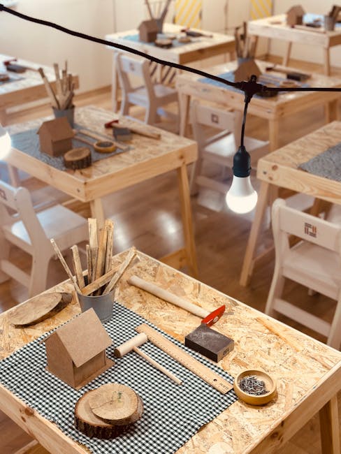 Laboratori creativi natalizi per le scuole al Ministero dell'Istruzione: tavoli con materiali per attività manuali e casette di legno.