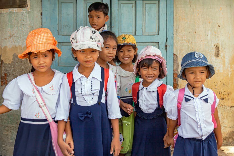 Bambini sorridenti in uniforme scolastica, pronti per la scuola vicino al bosco, grazie all'USR che facilita l'inserimento scolastico.