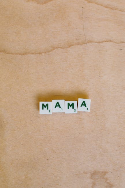Parola MAMA scritta con tessere di Scrabble su sfondo legno chiaro. Esercizi di russo base per imparare parole semplici.
