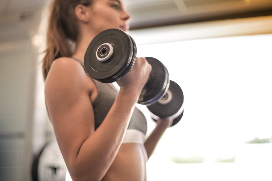 Donna che solleva pesi in palestra per calcolare il peso con il convertitore di misure, allenamento e fitness