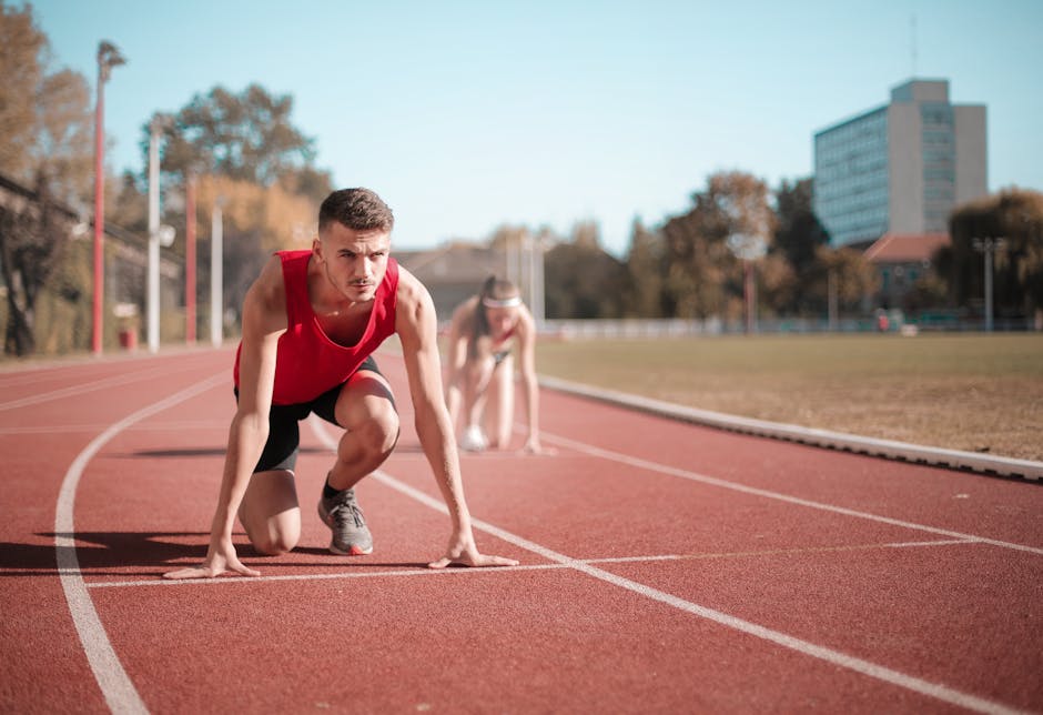 Corridore in posizione di partenza su pista di atletica, pronto a calcolare il tempo di corsa per migliorare le performance sportive.