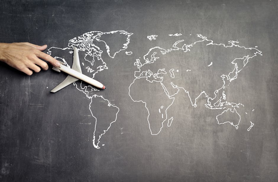 Mano che indica un aereo giocattolo su una mappa del mondo disegnata su lavagna, metafora di apprendimento personalizzato e didattica differenziata.