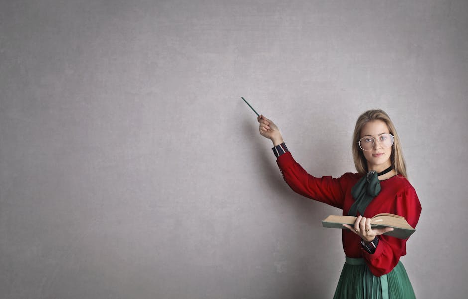 Insegnante spiega alla lavagna con libro e puntatore, didattica differenziata per valorizzare gli stili di apprendimento degli studenti