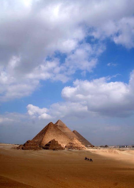 Le iconiche piramidi di Giza sotto un cielo azzurro e nuvoloso, simbolo dell'Antico Egitto e dei suoi eventi storici affascinanti.