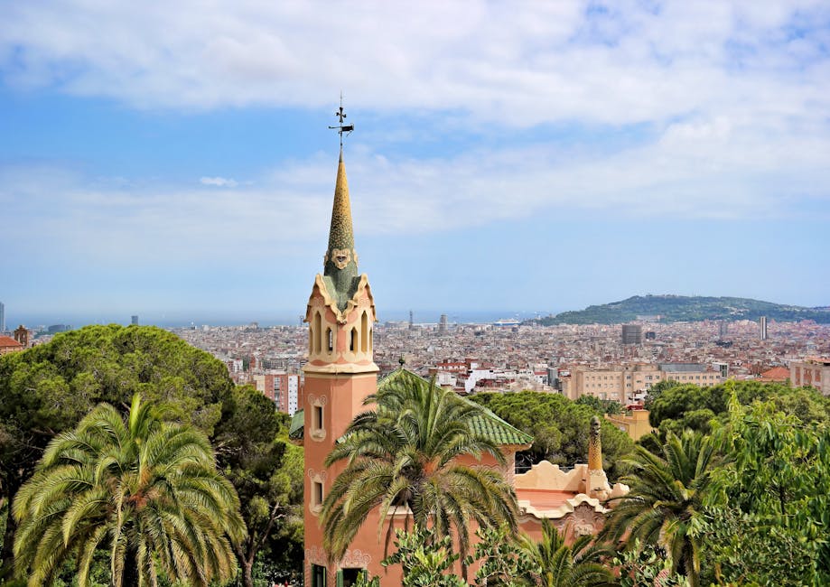 Vista panoramica di Barcellona dal Parco Güell con la caratteristica architettura di Gaudí in primo piano e la città sullo sfondo.