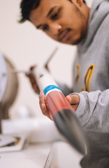 Studente di liceo scientifico esamina modello di razzo per esercizi di fisica quantistica e sviluppo competenze scientifiche.