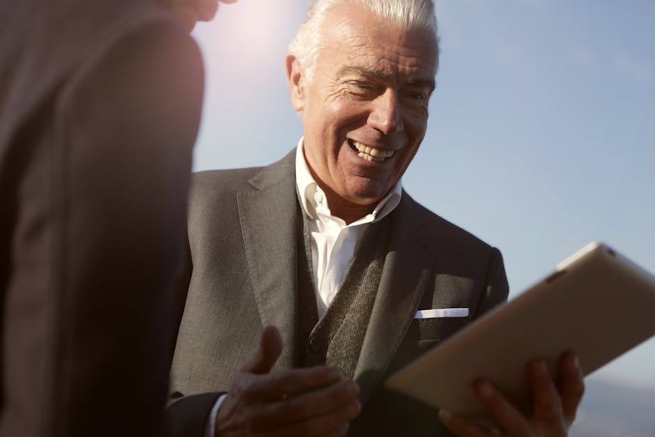 Uomo d'affari sorridente con tablet: pianificazione e strategie per affrontare l'esame con successo e ottenere risultati ottimali.