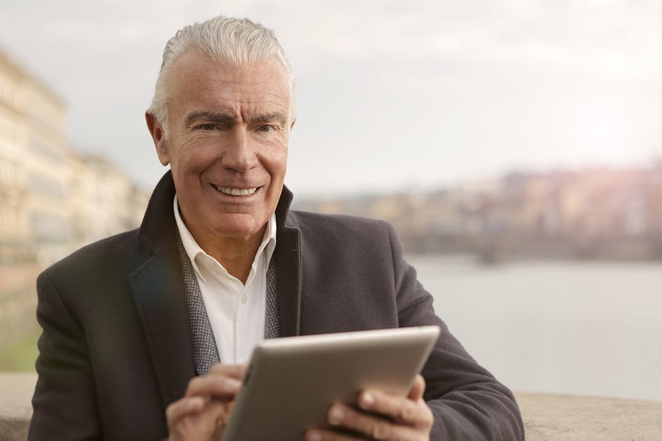 Uomo maturo sorridente usa tablet per connessioni globali e comprensione interculturale in un mondo sempre più interconnesso.