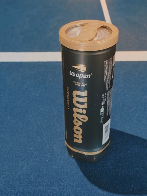 Tubetto di palline da tennis Wilson US Open, simbolo dei costi extra per le famiglie nell'assistenza scolastica per disabilità