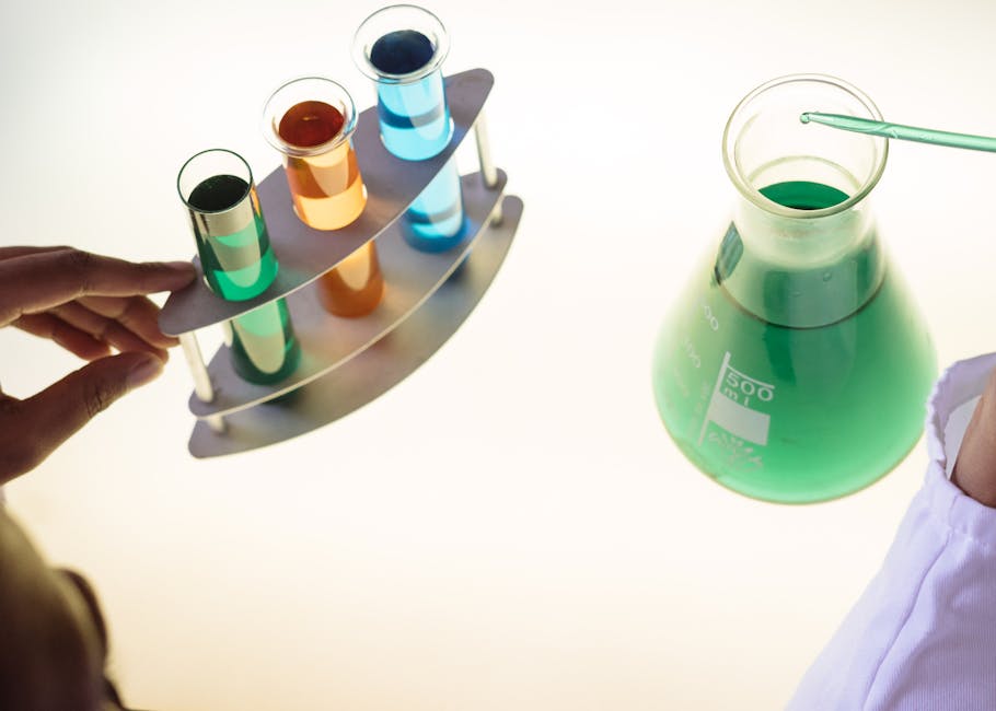Misurazione in laboratorio: provette colorate e beuta con liquido verde per analisi e calcoli di oz grammi