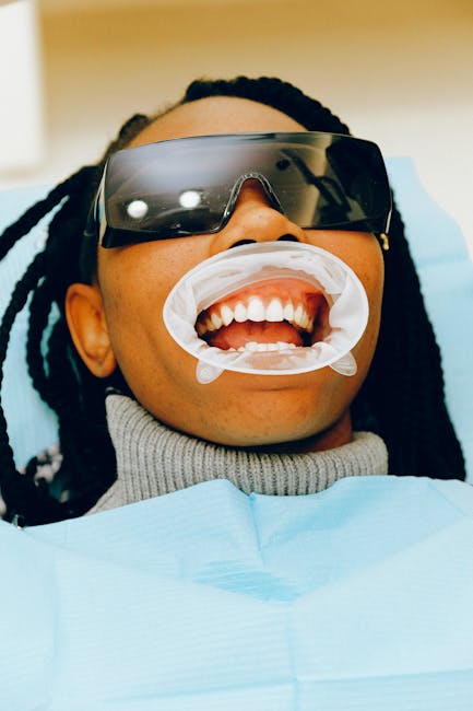 Donna con occhiali protettivi e divaricatore durante visita odontoiatrica, preparazione all'esame orale con strategia e cura dei denti