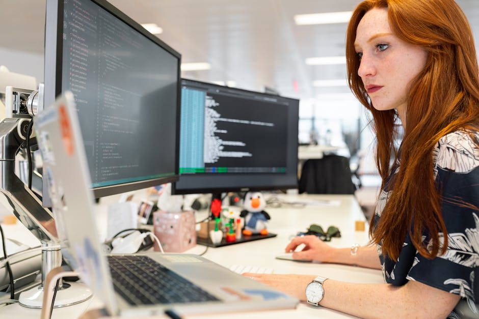 Donna che lavora al computer con due schermi, importanza della graduatoria nel mondo del lavoro e della programmazione