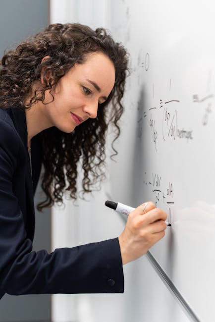 Donna scrive equazioni matematiche su lavagna bianca, Unitn Matematica formazione su misura, didattica innovativa e personalizzata