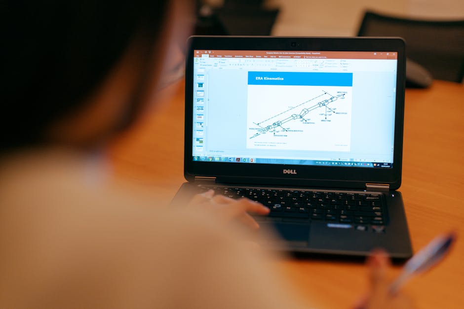 Lavoratore consulta schema tecnico su laptop durante lavoro agile: informazione sindacale e CCNL Istruzione e Ricerca