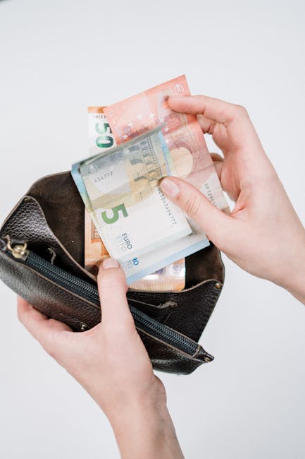 Contributo bollette 90 euro: mani che prelevano banconote da portafoglio, agevolazioni ISEE fino a 25000 euro per famiglie in difficoltà