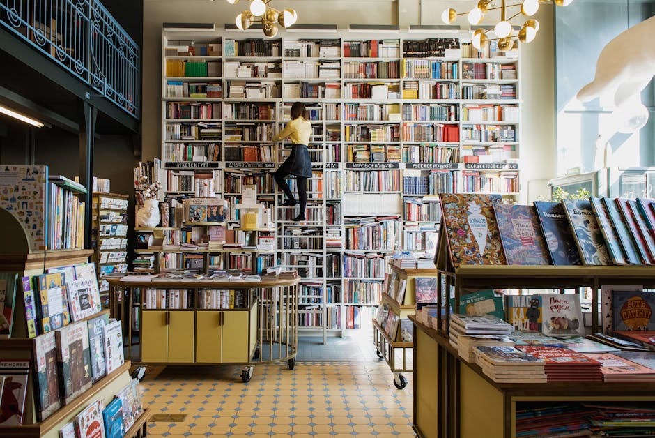 Libreria con scaffali pieni di libri e persona su scala, legno e varietà legnose per arredamento e costruzione librerie.