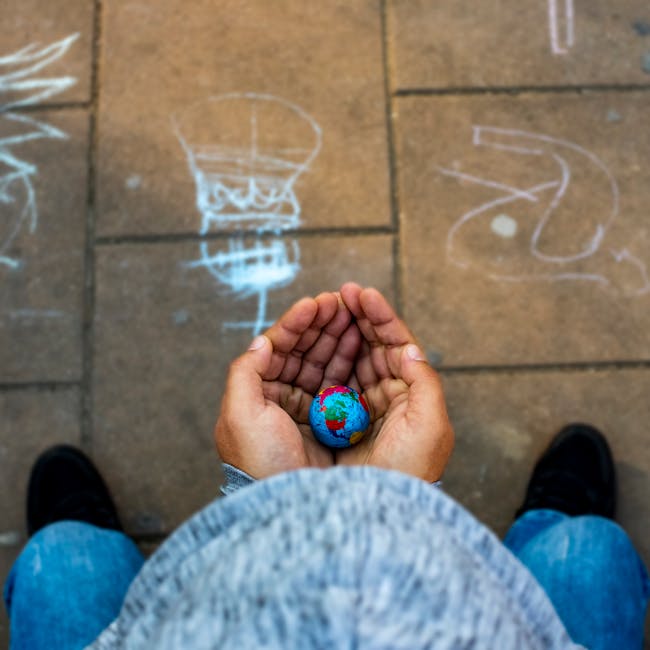 Giornata Mondiale delle Città: mani che sorreggono un piccolo globo terrestre, simbolo di futuro sostenibile e pianeta da proteggere.