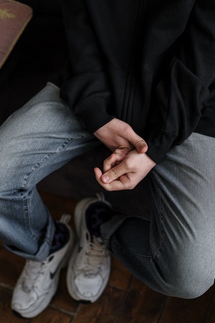 Giovane con mani giunte, simbolo di ansia e stress legato alla salute mentale giovanile in Lombardia e al ruolo della scuola.