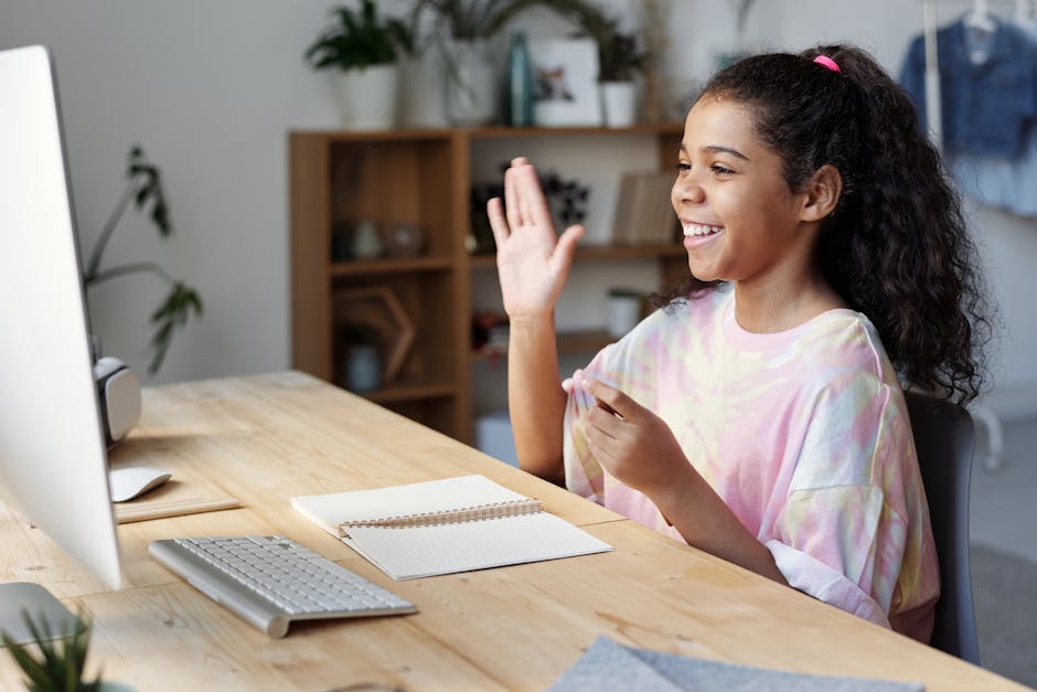 Ragazza sorridente partecipa a lezione online personalizzata, saluta lo schermo del computer, apprendimento interattivo e coinvolgente.