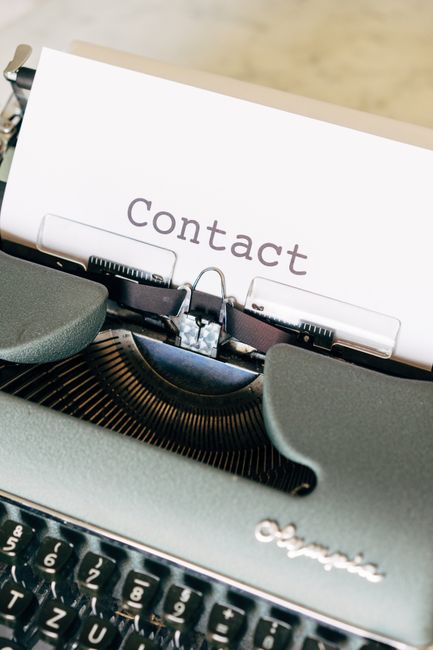 Macchina da scrivere Olympia con foglio che riporta la parola Contact, ideale per comunicazioni e call for paper