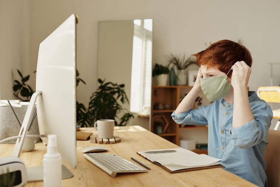 Ragazzo con mascherina davanti al computer: educazione alla sicurezza sul lavoro nelle scuole per la prevenzione dei rischi