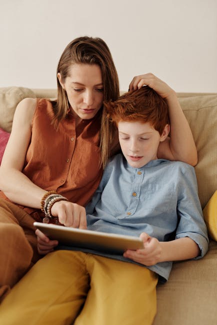 Madre e figlio guardano un tablet insieme sul divano, un momento di relax e apprendimento digitale in famiglia dopo la scuola.