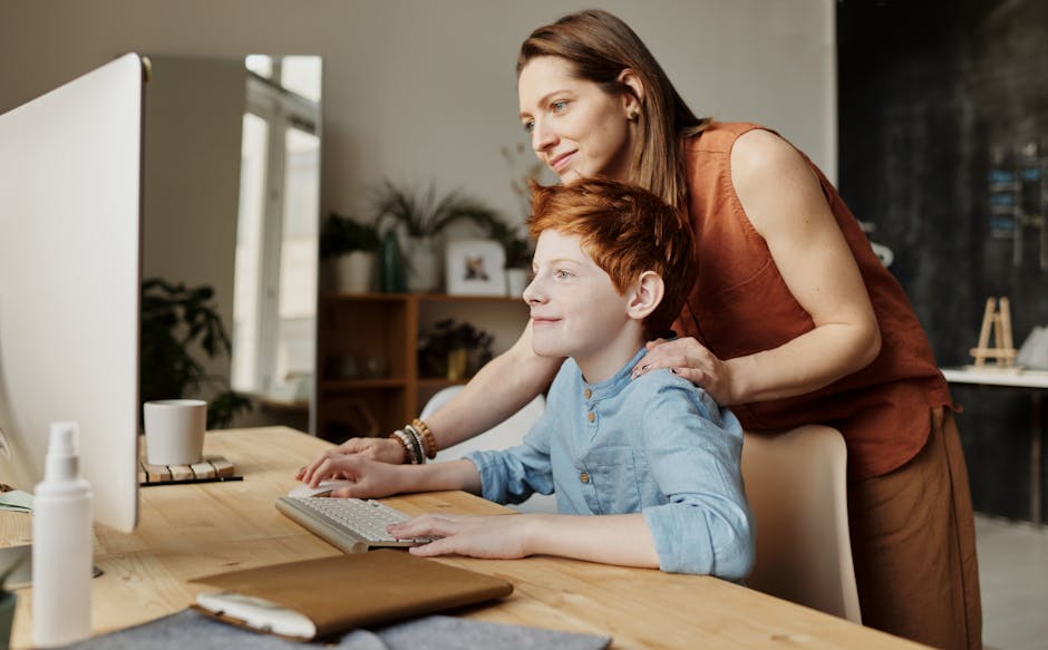 Madre che aiuta il figlio a fare i compiti al computer, supportando l'apprendimento senza stress e favorendo un ambiente positivo.