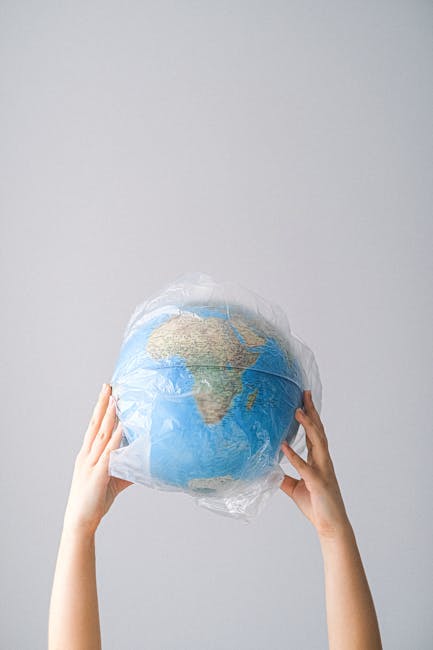 Globo terrestre avvolto in plastica: simbolo di inquinamento e necessità di sviluppo sostenibile per la Giornata Mondiale dell'Informazione.