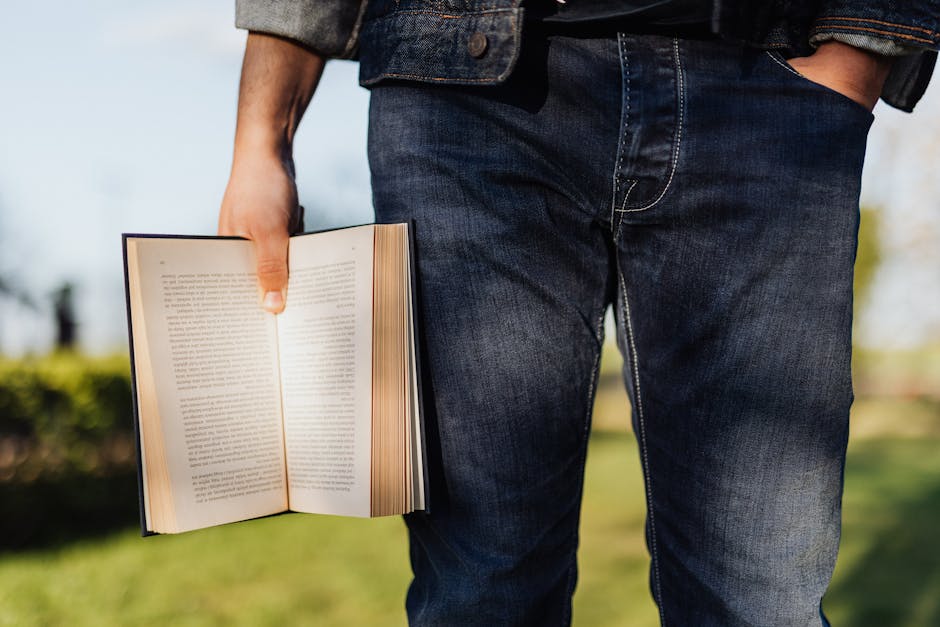 Uomo con libro aperto in mano, metafora di conoscenza e crescita personale legata all'educazione sessuale e affettiva.