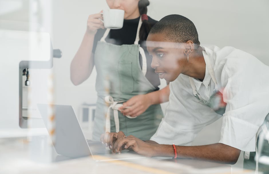 Due donne al lavoro con un laptop, una beve caffè. Concetto di lavoro di squadra e analisi dati per esercizi di fisica.