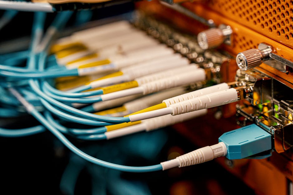 Cavi in fibra ottica connessi a un server di data center, dettaglio dei connettori e dell'infrastruttura di rete per Meta e Corning.