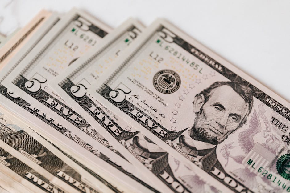 Banconote da 5 dollari USA impilate, simbolo di budget e finanziamenti per la Carta del Docente e la sua ripartizione tra i beneficiari.