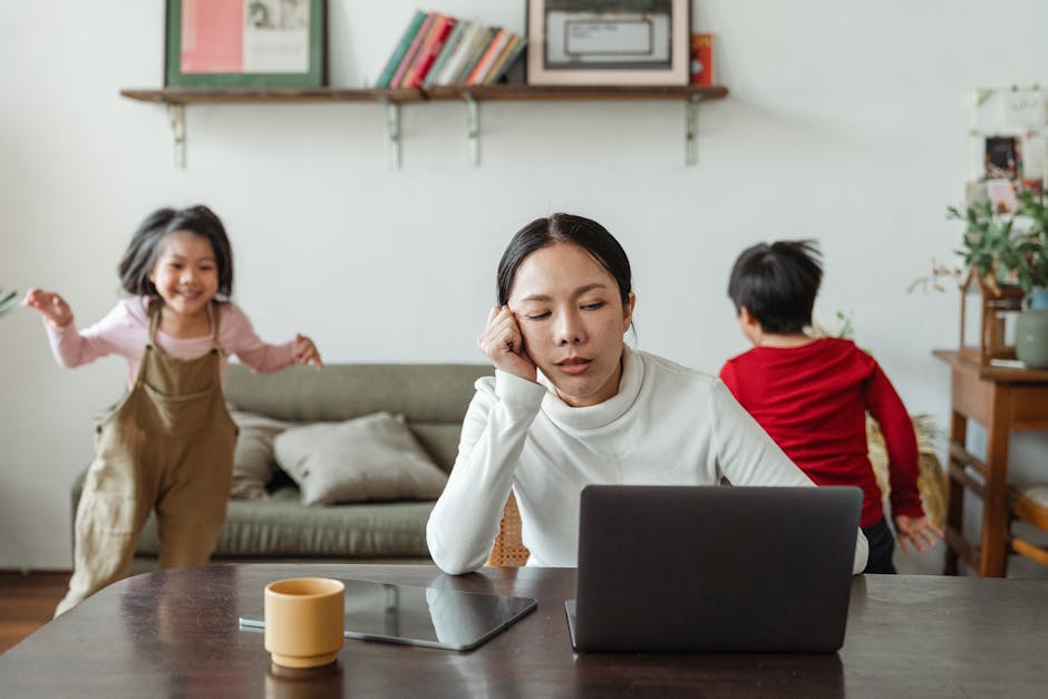 Insegnante stanca lavora da casa al computer con bambini che giocano, sfide dell'insegnamento a distanza e tecnologia.