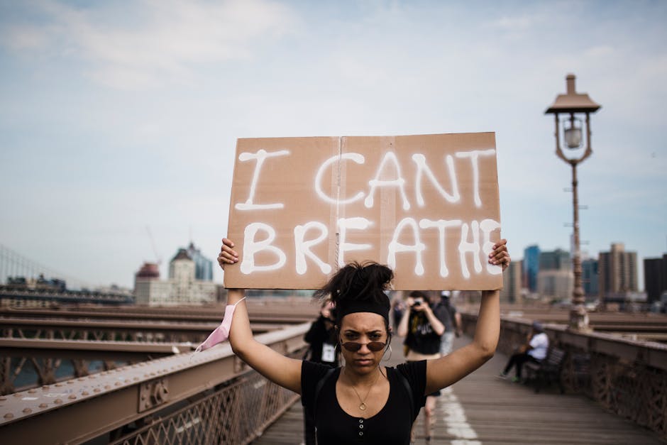 Manifestazione per i diritti civili: donna con cartello I can't breathe, simbolo di disuguaglianze e necessità di politiche sociali inclusive.