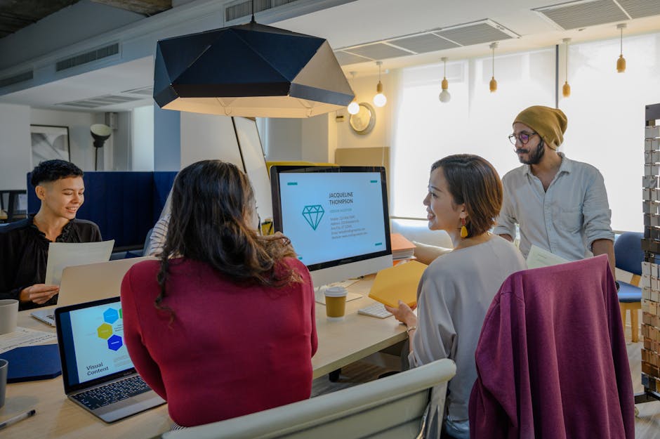 Team di lavoro collabora in ufficio moderno, esempio di politiche flessibili per un'organizzazione lavorativa innovativa e produttiva.