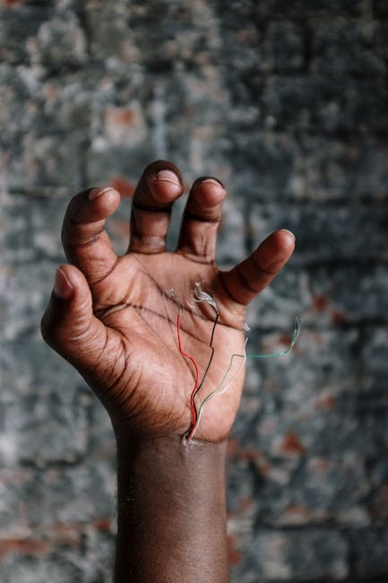 Mano di persona di colore che tiene fili elettrici colorati simbolo di connessioni e diversità nell'innovazione strategica