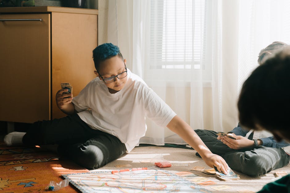 Bambino con capelli blu gioca a carte sul pavimento con amici, attività educativa coinvolgente e divertente per bambini