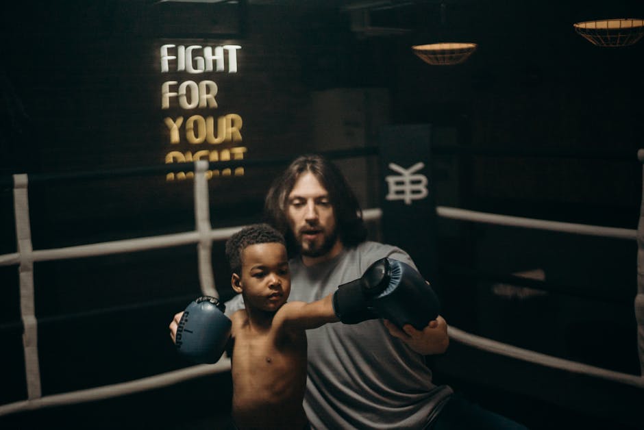 Bambino con guantoni da boxe allenato da un adulto: applicazione pratica della fisica nel movimento e nell'equilibrio