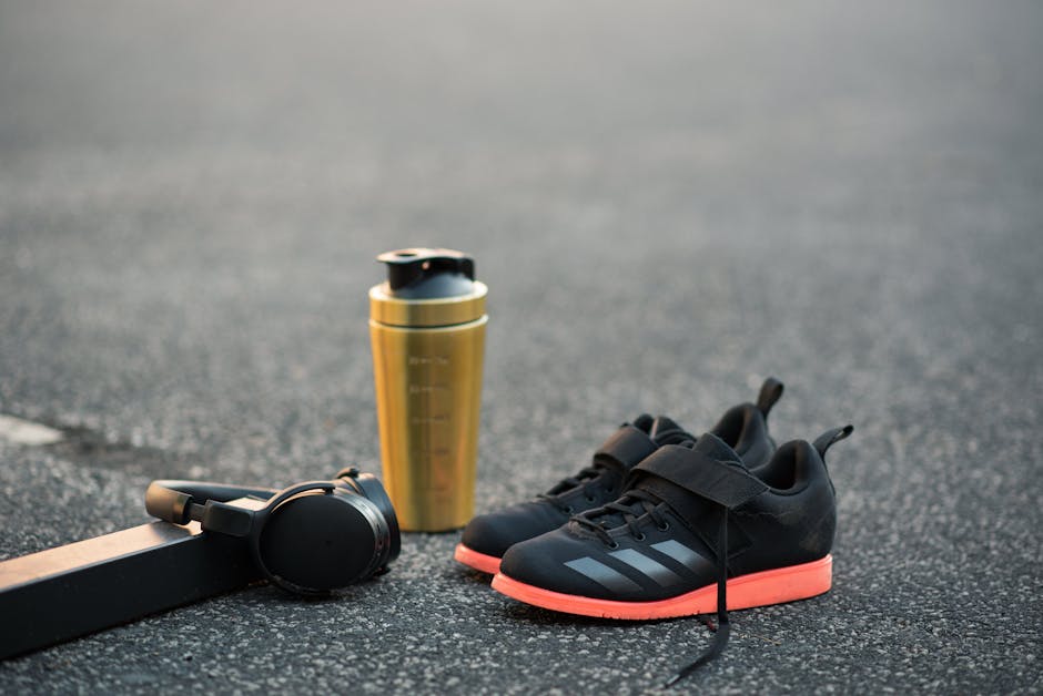Scarpe da ginnastica comode per educazione fisica, borraccia e cuffie per allenamento: comfort e performance ottimali.
