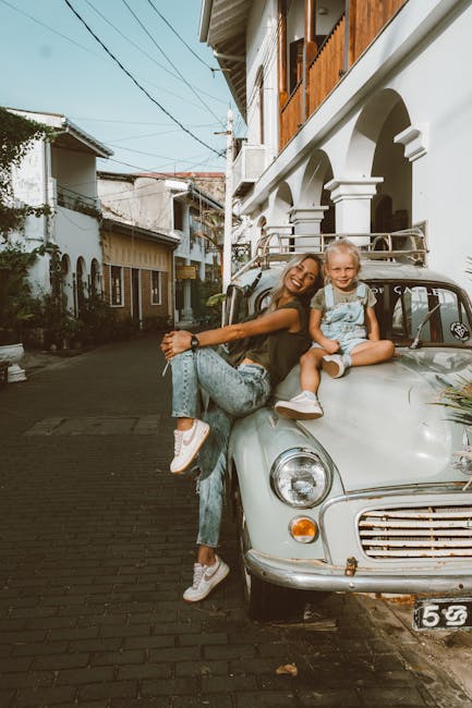 Madre e figlia sorridenti su auto d'epoca, simbolo di un'infanzia spensierata e un viaggio senza tempo come Peter Pan.
