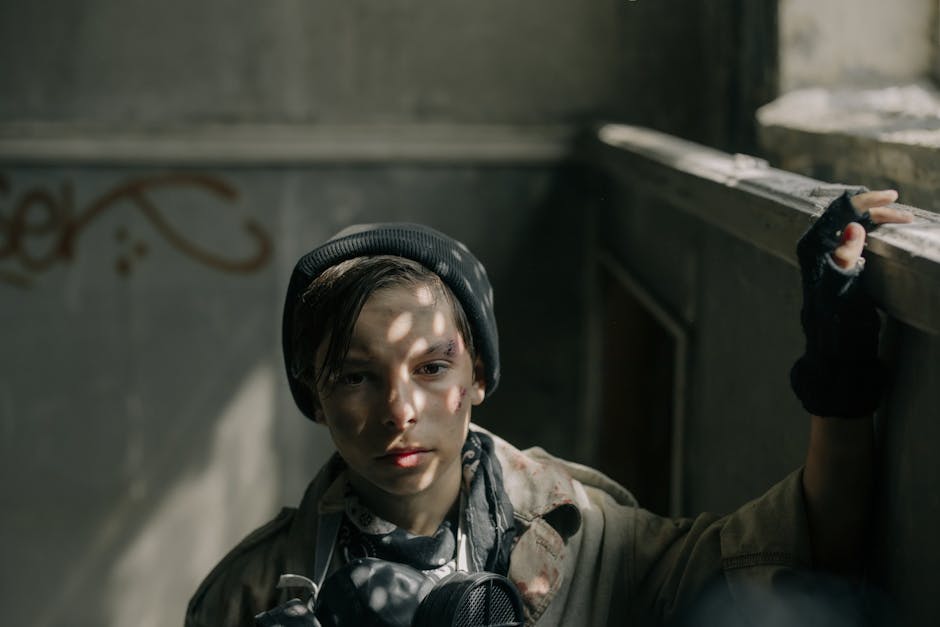 Ragazzo resiliente con maschera antigas in ambiente post-apocalittico, simbolo di forza e adattamento alle avversità ambientali e sociali.