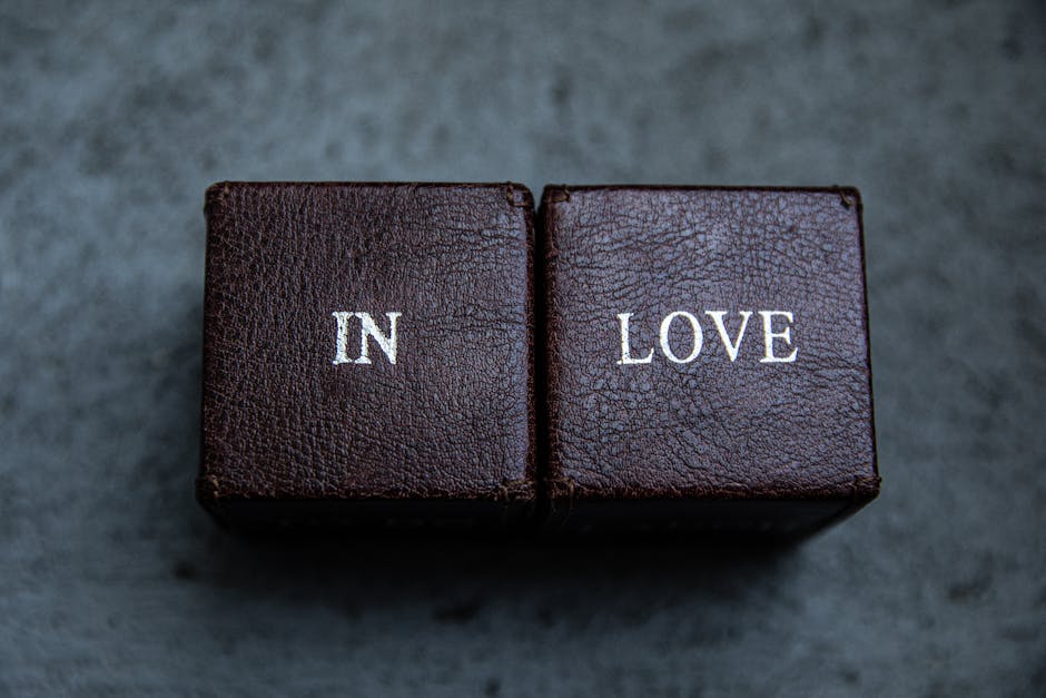 Due cubi marroni con scritta IN LOVE, concetto di amore e radice quadrata di 1, simbolo di unione e fondamento matematico.