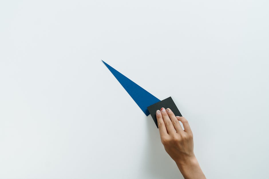 Pittura murale fai da te: mano che applica vernice blu con spugna su parete bianca per decorare piccoli spazi con stile.