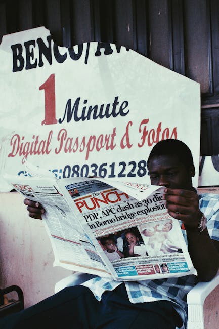 Uomo legge giornale The Punch con titolo su scontri politici, sfondo insegna digitale, alfabetizzazione mediatica e consapevolezza digitale