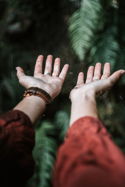 Esperienza sensoriale con l'acqua: mani aperte raccolgono la pioggia, un'attività pratica per bambini a contatto con la natura e l'ambiente.
