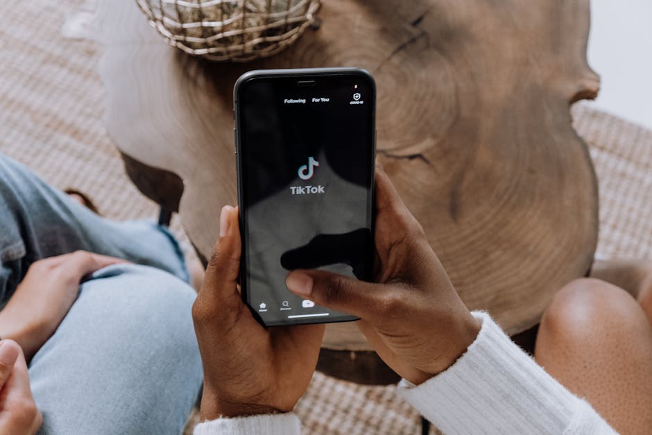Smartphone con app TikTok: focus sulla battaglia legale per la protezione dei minori sui social network Meta e TikTok.