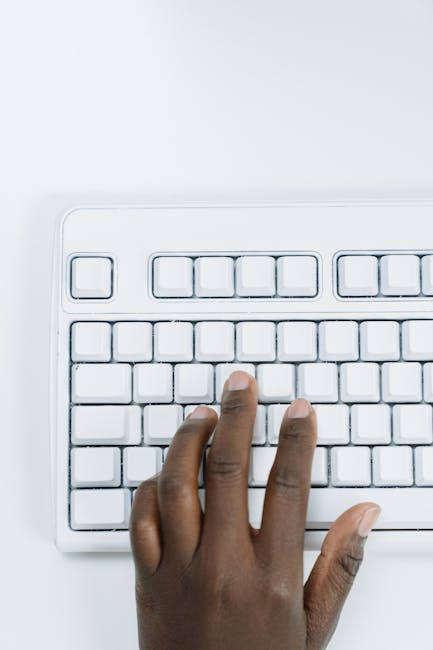 Calcolo assegno unico 2026: mano digita su tastiera bianca, simulazione aumento Istat fino a 204 euro mensili per famiglie.