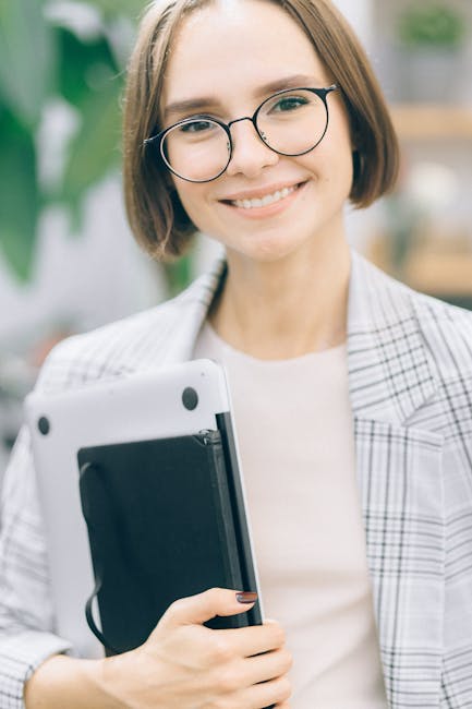 Insegnante moderna sorridente con laptop, simbolo dell'innovazione nell'educazione contemporanea e del ruolo chiave del docente.