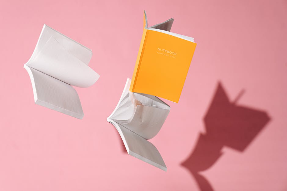 Quaderni aperti che fluttuano su sfondo rosa, metafora dell'apprendimento e della spiritualità nella Scuola Domenicana.