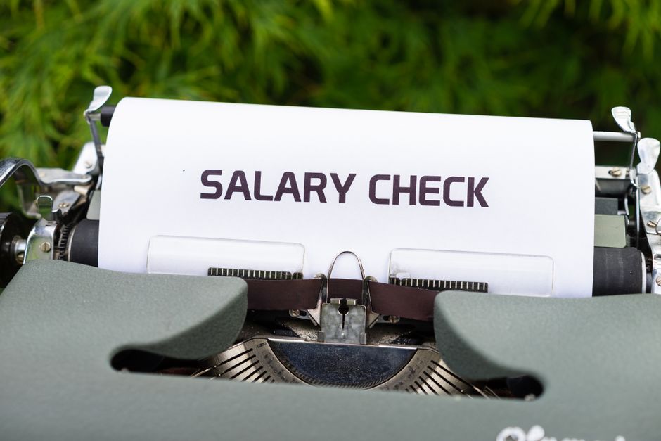 Macchina da scrivere con foglio che riporta la scritta SALARY CHECK, simbolo di stipendio e pagamenti per dirigenti scolastici.